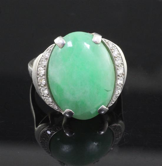 A platinum, cabochon jade and diamond set oval dress ring, size J/K.